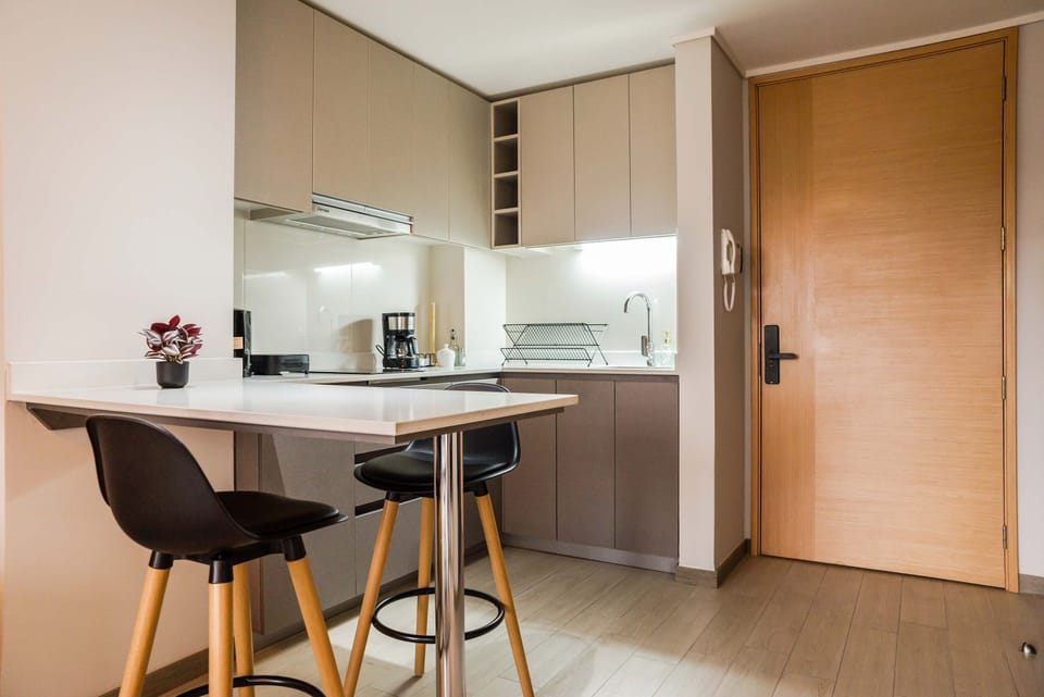 Sleek and modern kitchen perfect for a quick meal or morning coffee, featuring stylish bar seating and ample counter space.