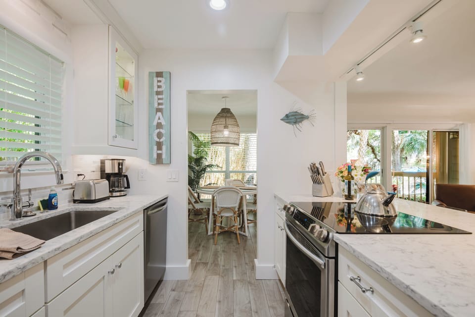 Kitchen is fully equipped with dishes and pots & pans.