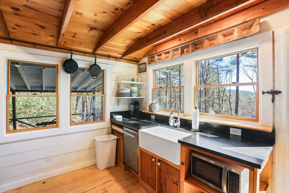 The dishes can wait. You linger a little longer at the sink, soaking in the view—sunlight on the pines, ridge lines in the distance, and the hush of the woods just beyond the glass. In this kitchen, even washing up feels like part of the retreat. Everything slows here.