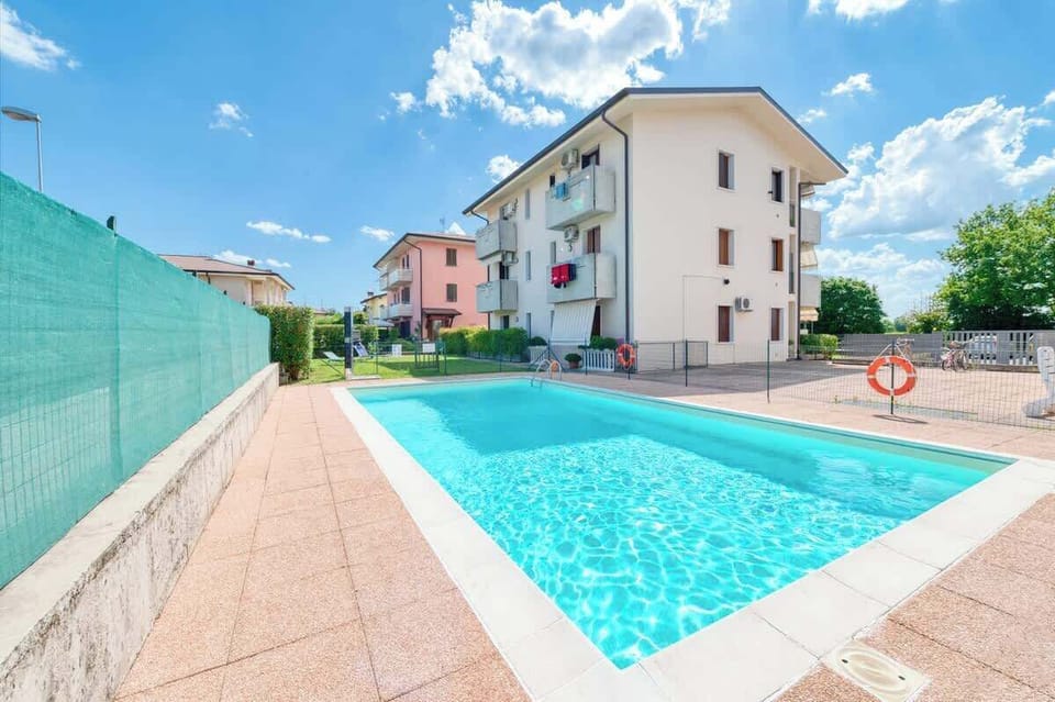 Ampia piscina esterna con solarium e giardino con area Relax e lettini sdraio riservati