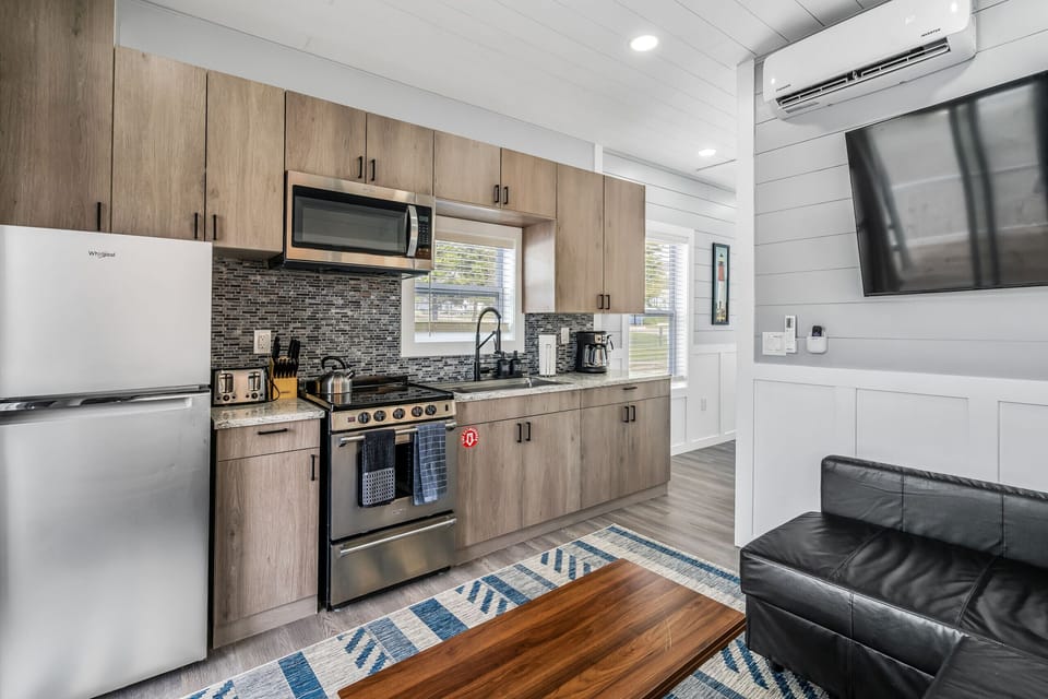 Modern kitchen and cozy  living space featuring full=size appliances, a comfortable sofa, and everything you need for a relaxing stay on the water.