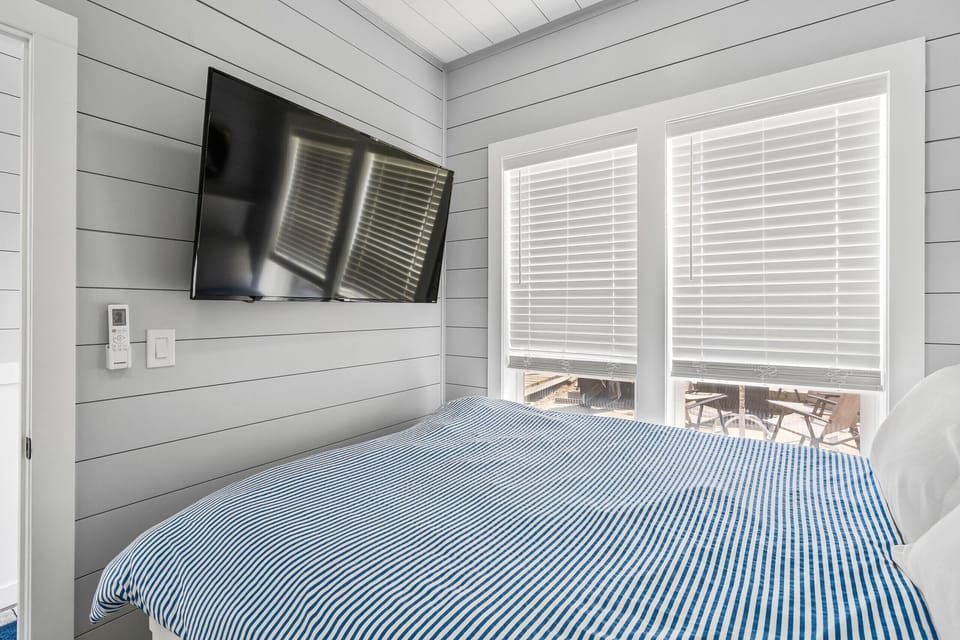 Bright windows  and a wall-mounted TV
