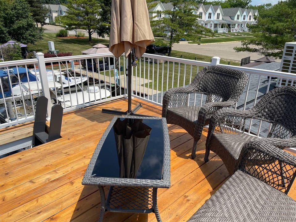 Enjoy a sunny rooftop patio with cozy wicker seating, a glass-top table, and open views of the marina and charming neighborhood.