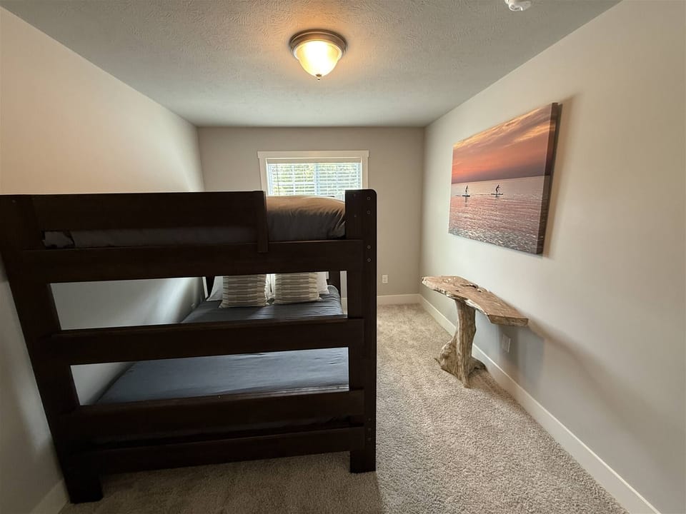 Queen-over-queen bunk room, soft carpeting, and calming coastal decor–perfect for families or groups.