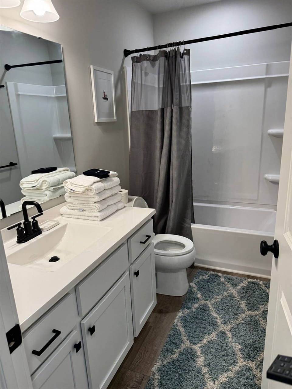 Spotless bathroom with full shower and tub combo, fresh towels, and modern fixtures.