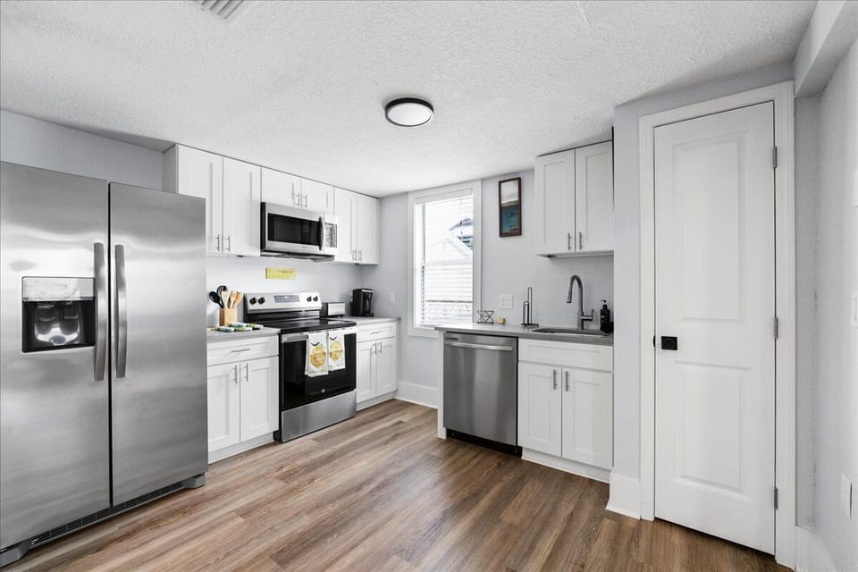 Cook a full family breakfast or pour a glass of wine after dinner — your stocked kitchen with stainless appliances and white cabinetry has everything you need.