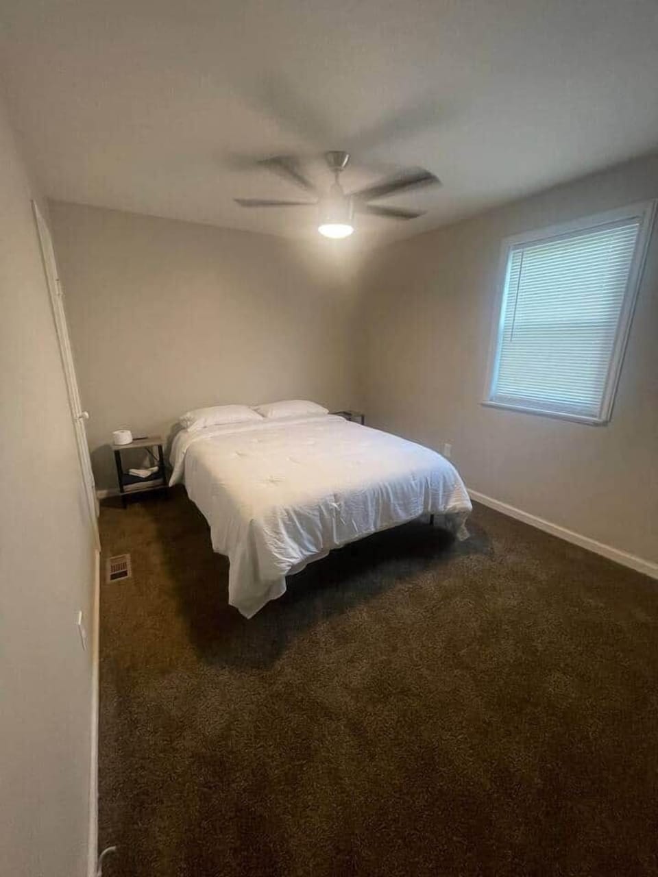 This inviting bedroom includes a queen-sized bed, and a window that provides natural light and a lovely view. 