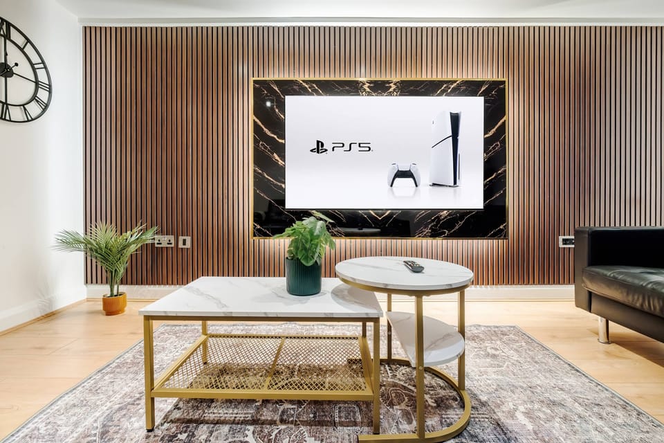 Living Room | Elevated luxury awaits in the living room, featuring a beautifully decorated space with a 70 inch smart TV, an open plan fully equipped kitchen, and a dining table seating up to 6 guests, perfect for sharing meals in comfort.