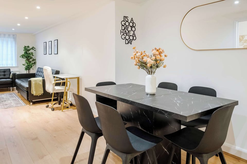 Living Room | Elevated luxury awaits in the living room, featuring a beautifully decorated space with a 70 inch smart TV, an open plan fully equipped kitchen, and a dining table seating up to 6 guests, perfect for sharing meals in comfort.