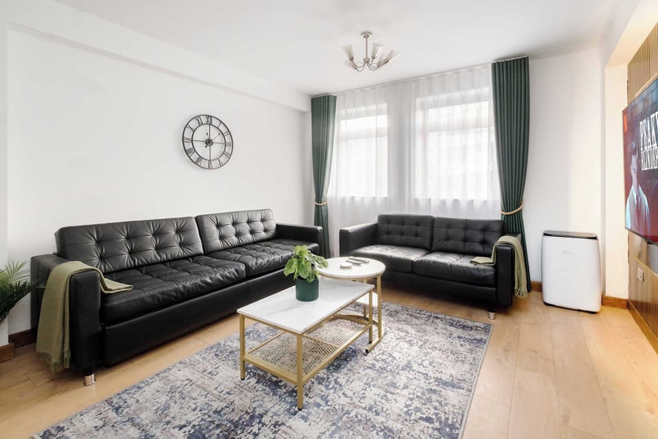 Living Room | Elevated luxury awaits in the living room, featuring a beautifully decorated space with a 70 inch smart TV, an open plan fully equipped kitchen, and a dining table seating up to 8 guests, perfect for sharing meals in comfort.