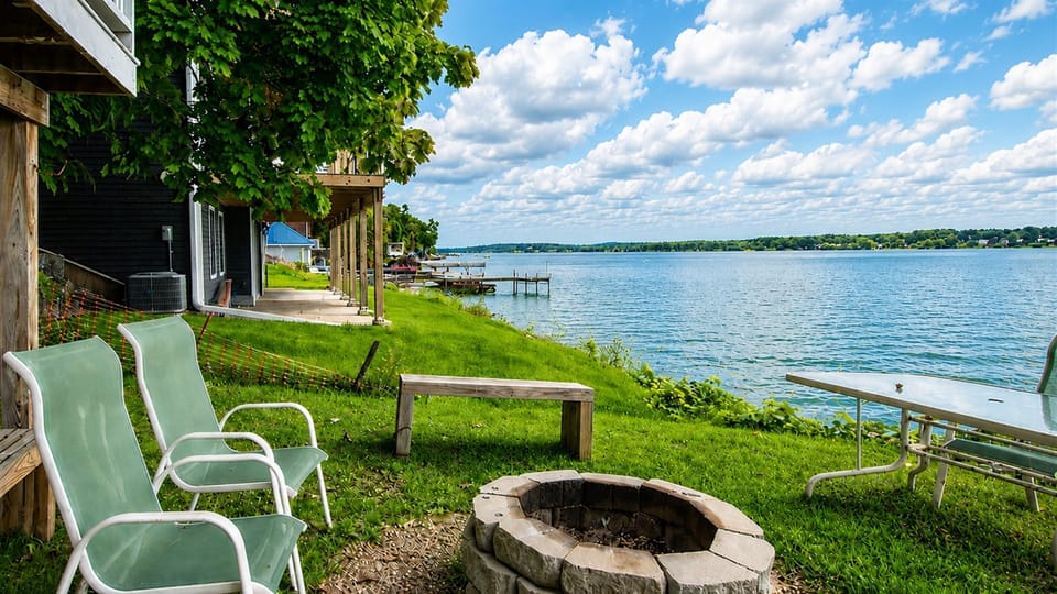 Grassy lakeside yard with chairs for front-row water views.
