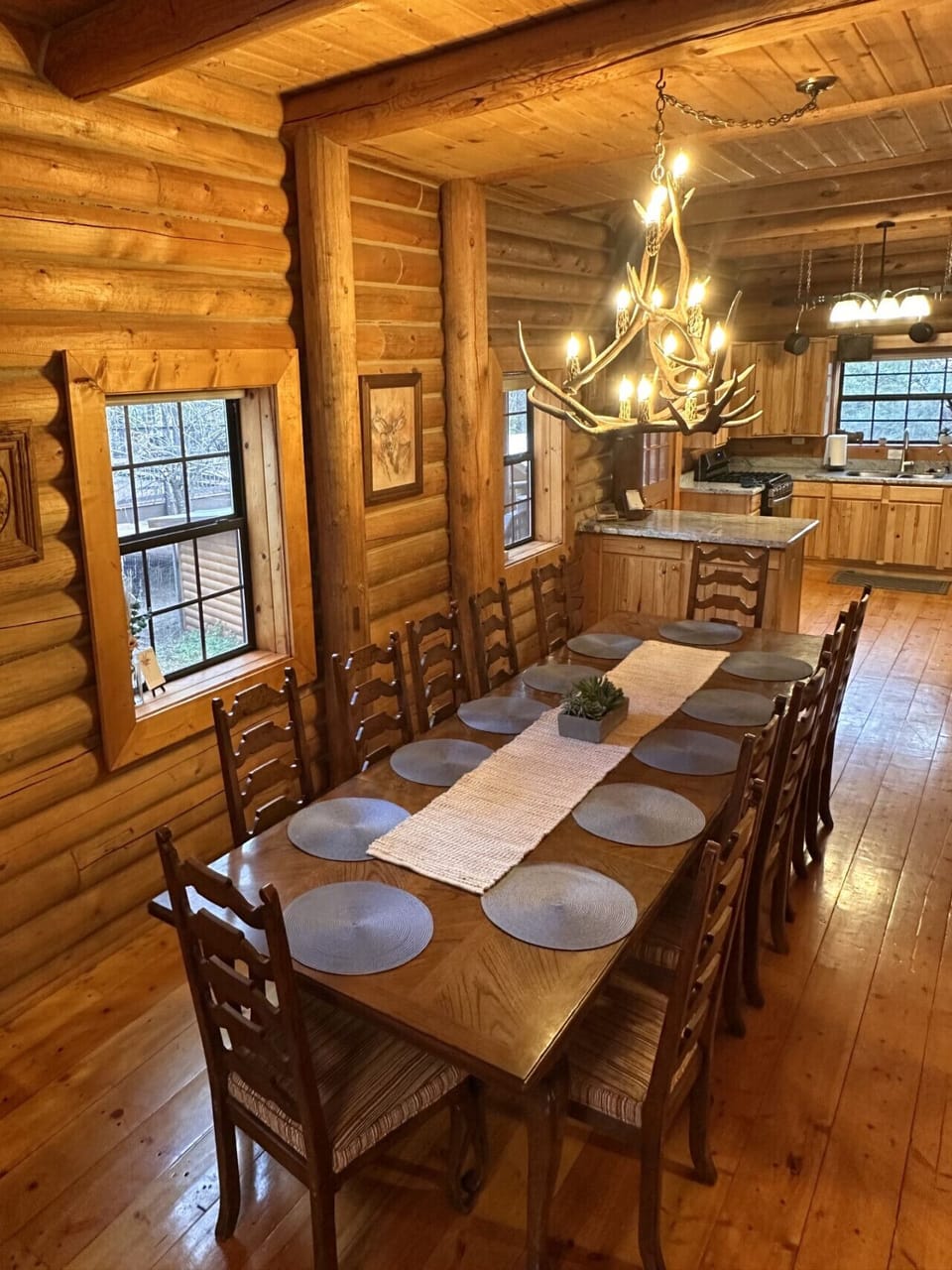 The fully equipped kitchen opens to a generous dining space with seating for up to 16 guests, making it perfect for family meals, group gatherings, and shared cabin moments.