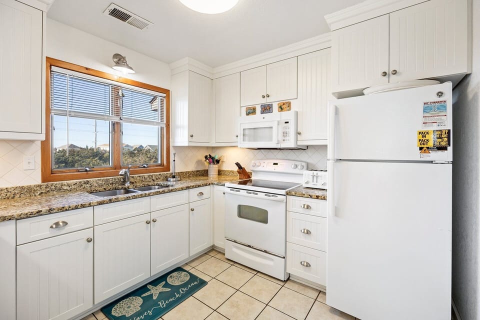 The kitchen features granite countertops and ample prep space.