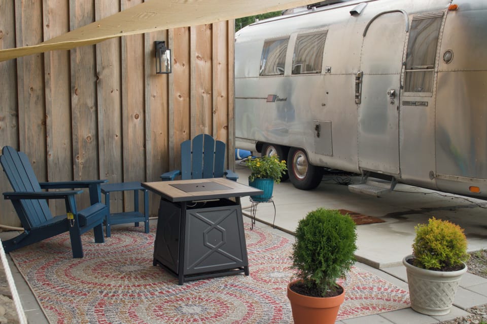Private Airstream patio with fire pit, lounge chairs, and cozy outdoor charm