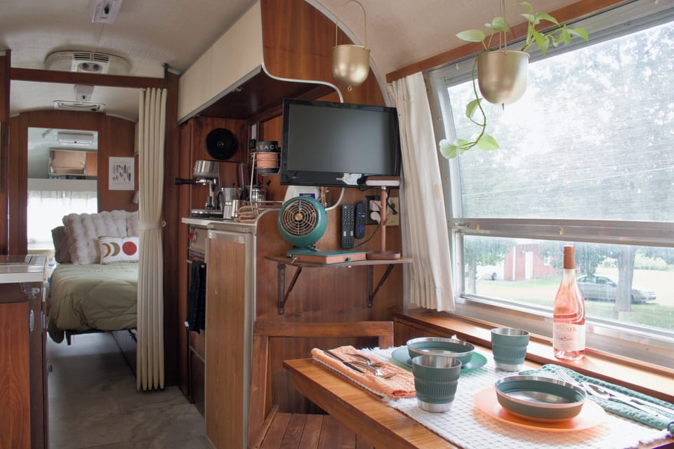 Cozy vintage camper with sunny dining nook and warm wood interiors