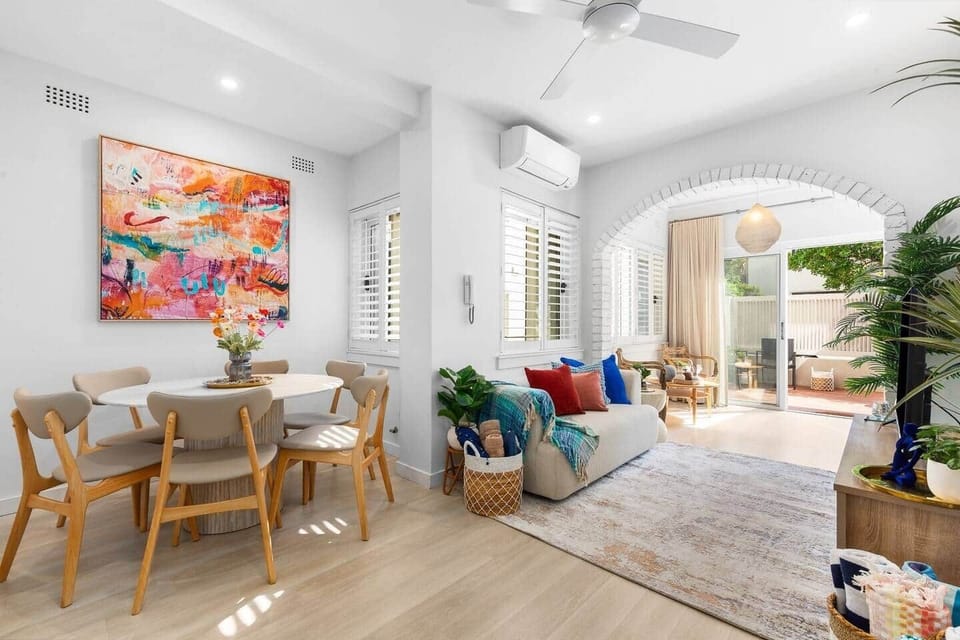 Living room with sofa and dining area in modern Bondi apartment