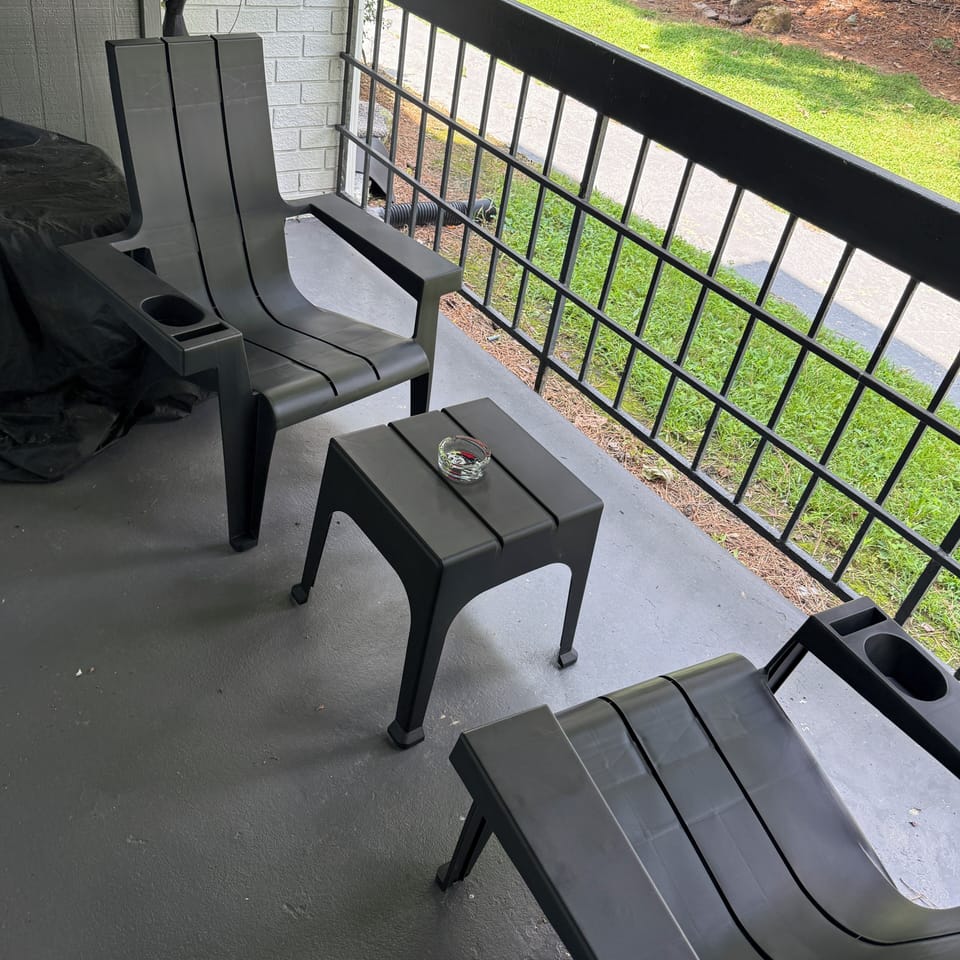 Balcony area 2 chairs and a table with charcoal grill