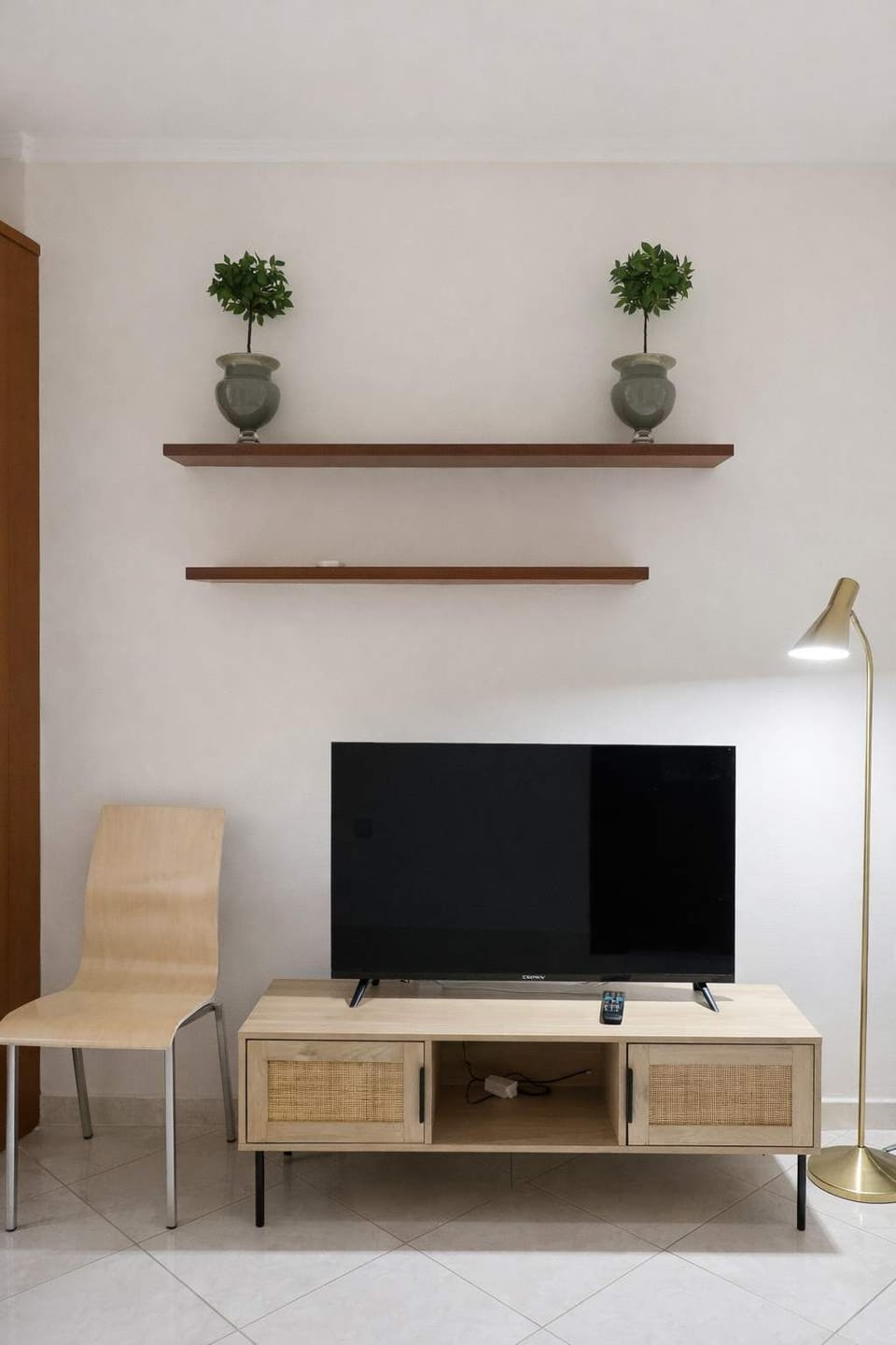 TV Area with Shelving and Seating
Flat-screen TV with storage shelves and a relaxing seating corner.