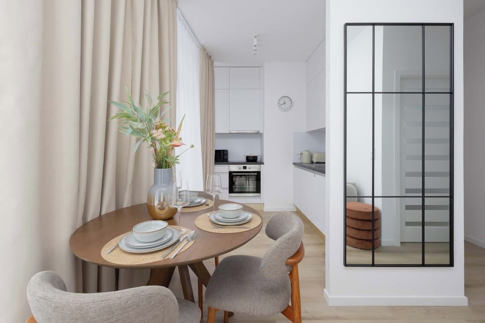 A round table with an elegant setup invites shared breakfasts and relaxed dinners in an intimate atmosphere.