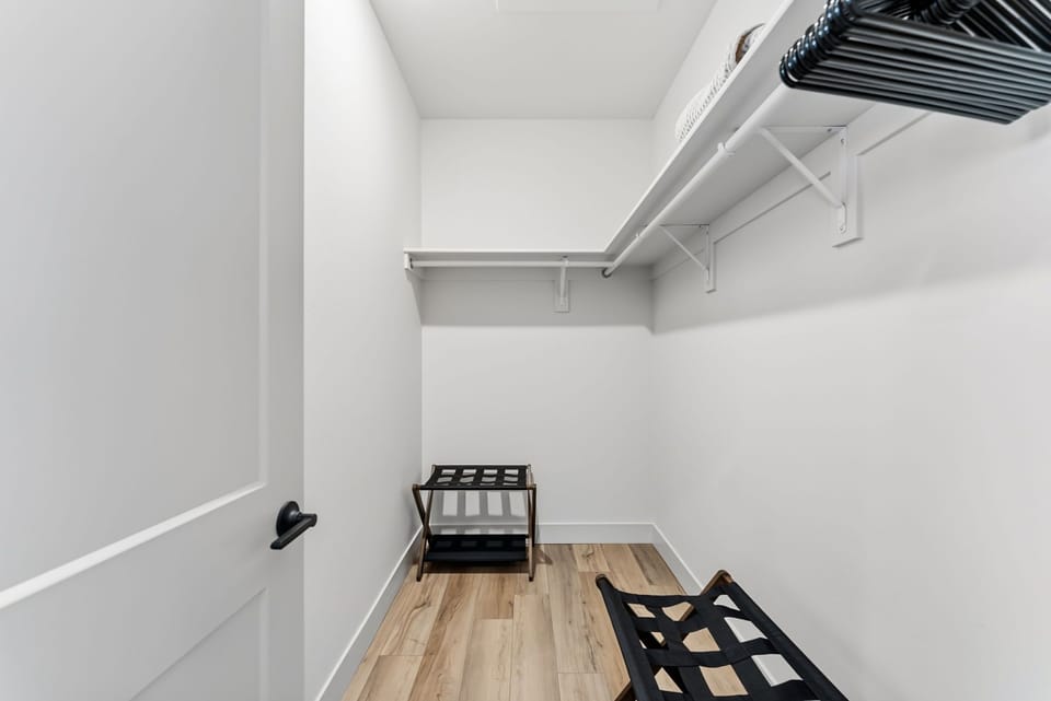 Your spacious walk-in closet offers generous hanging space and shelving, with elegant hardwood floors creating a luxurious dressing experience.