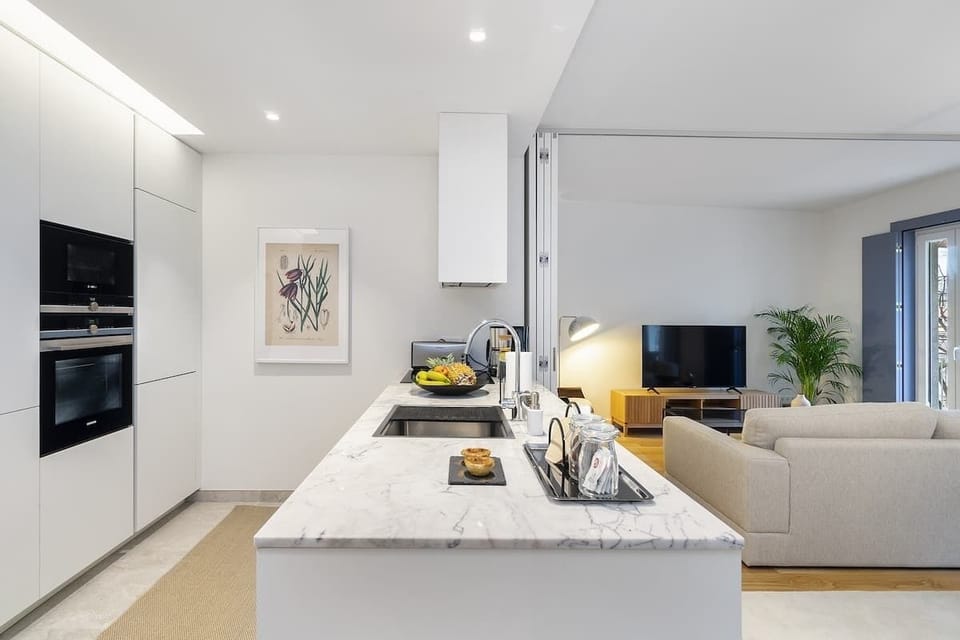 Modern open-plan kitchen connected to the living area. Features a marble countertop, built-in SIEMENS appliances. Bright and functional, perfect for cooking and entertaining mix. 