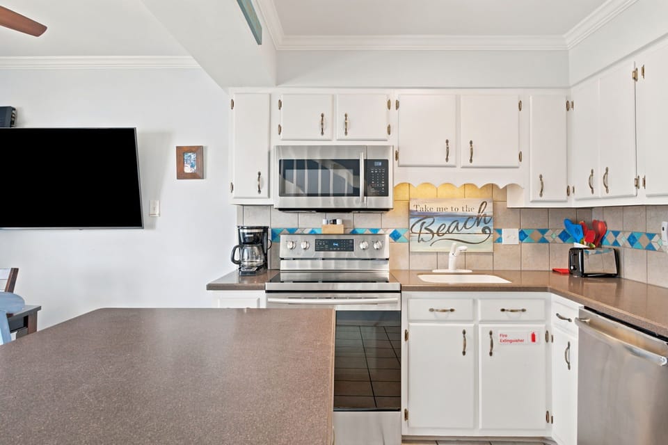 Your fully-equipped kitchen features granite countertops, stainless appliances, and cheerful beach-themed touches—perfect for preparing family meals together during your stay.