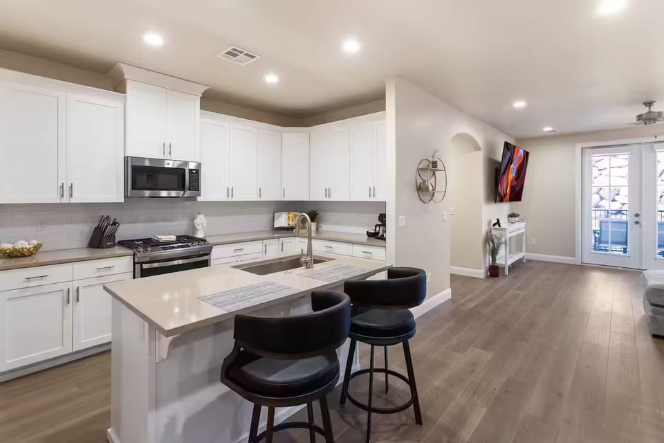 Kitchen island bar seating with room to prepare and enjoy meals together with place settings for your group comfortably, with 6 additional seats on outdoor patio.