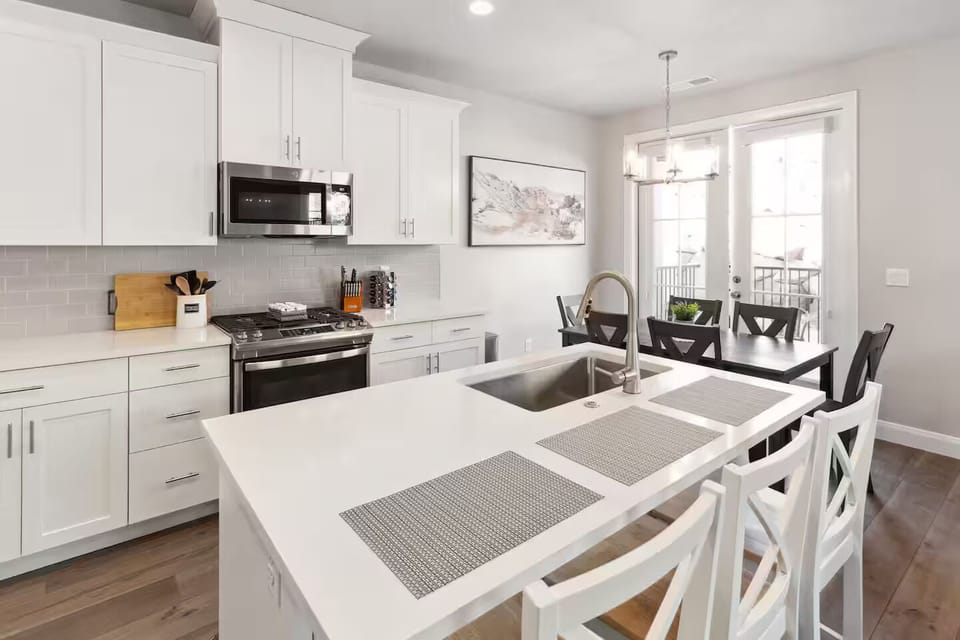 Fully stocked kitchen with stainless steel appliances and thick solid-surface countertops opening to the dining area and great room.