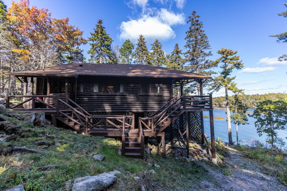 Historic log cabin nestled on over 5 private acres, featuring 360 ft. of pristine oceanfront and surrounded by peaceful Maine woodland.