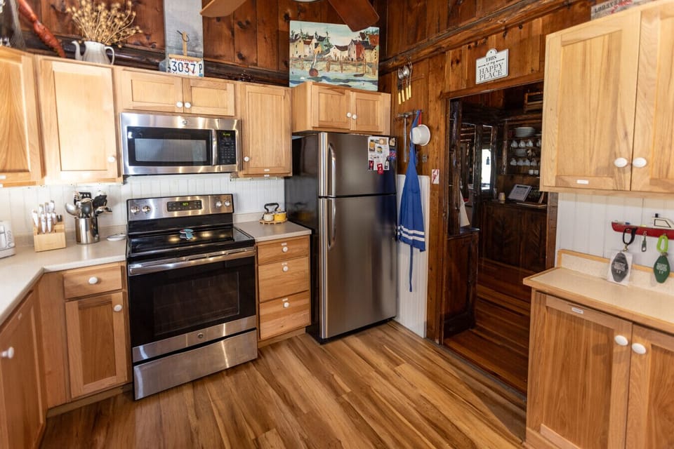 Bright and functional kitchen stocked with plenty of dishes, cookware, and small appliances - perfect for preparing meals after a day outdoors.”