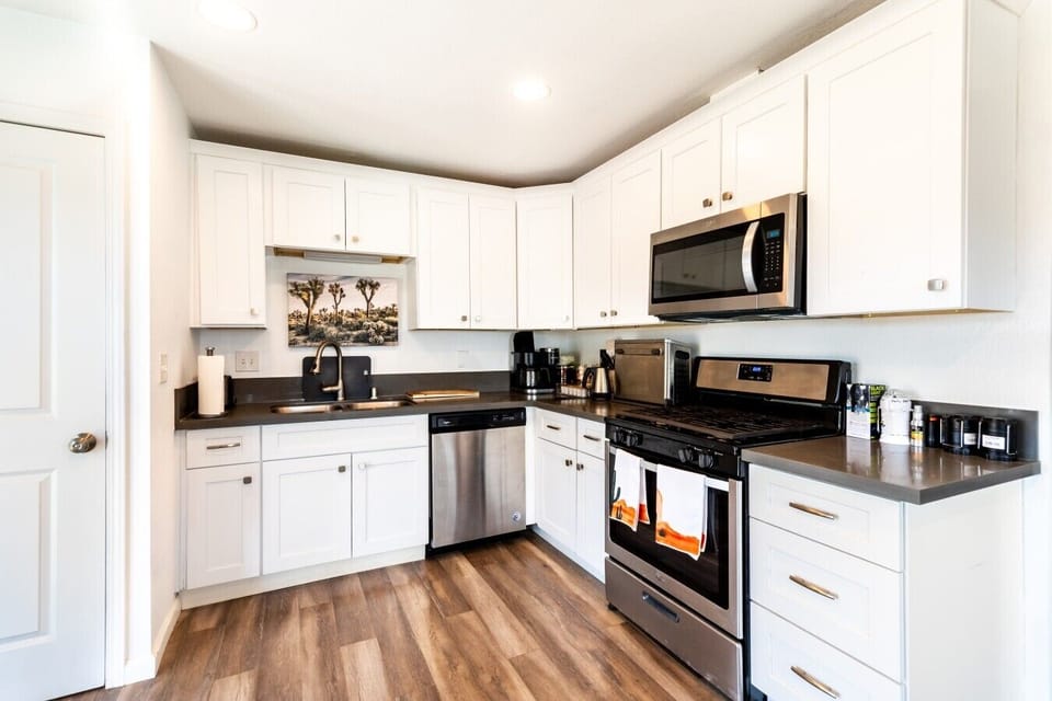 Kitchen | Stainless Steel Appliances | Dark Countertops & Hardwood Floors