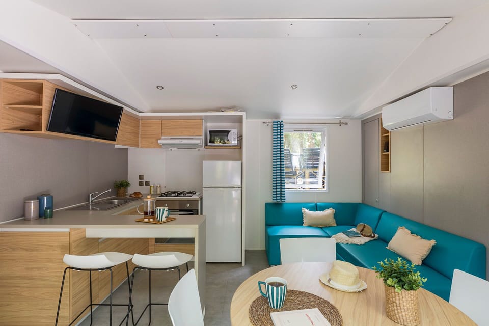Inside, the modern kitchen area, complete with stylish cabinetry and an open layout, invites you to prepare meals while enjoying the comfort of the living space.