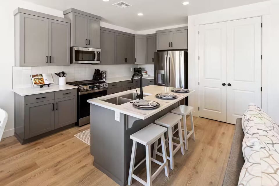 Fully stocked kitchen with brand-new stainless-steel appliances and thick solid-surface countertops opening to the great room
