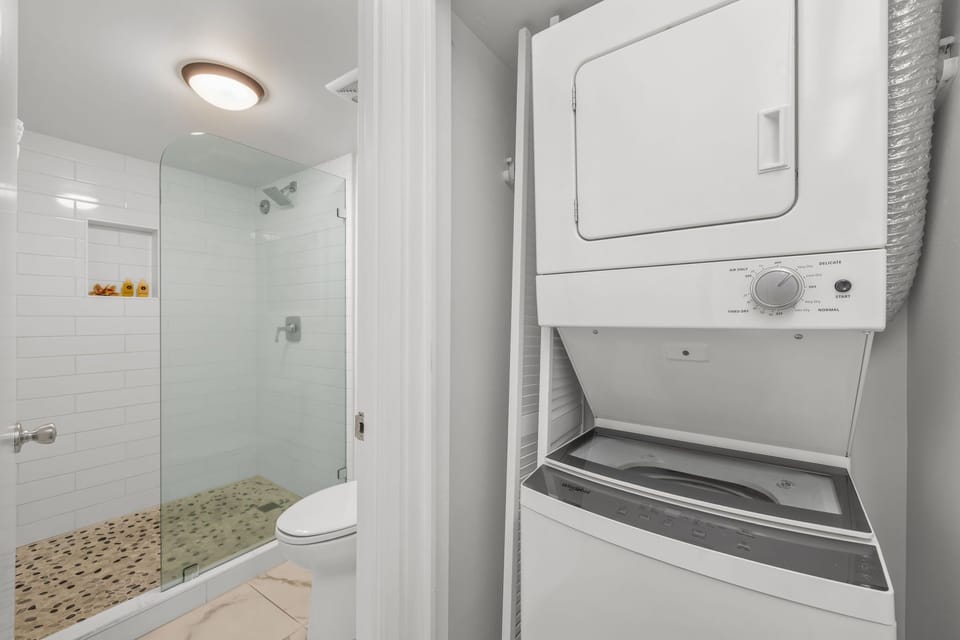 Full laundry closet with stacked washer and dryer provides added convenience for extended stays.