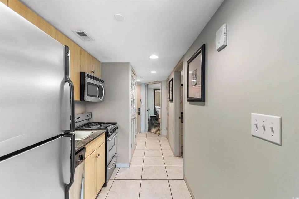 Bright kitchen and dining space with modern finishes, stainless steel appliances