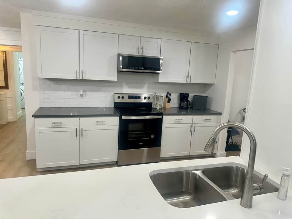 Modern Kitchen: Glass-top range, microwave & coffee station. Designed for large-scale meal prep.