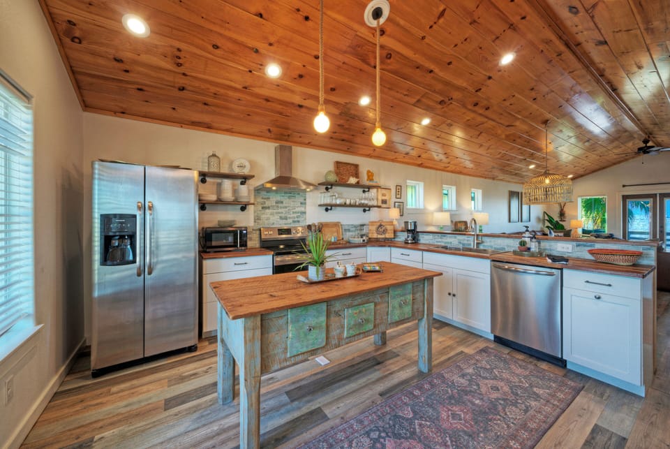 Bright, coastal-inspired kitchen with warm wood finishes—perfect for casual breakfasts, sunset cocktails, and gathering with friends.