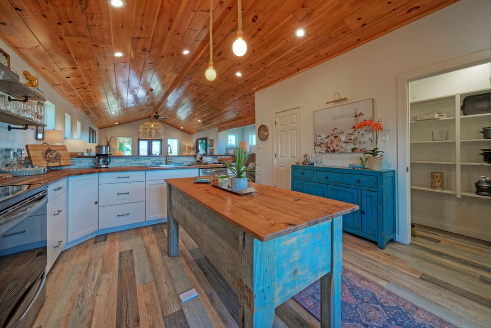 Bright, coastal-inspired kitchen with warm wood finishes—perfect for casual breakfasts, sunset cocktails, and gathering with friends.