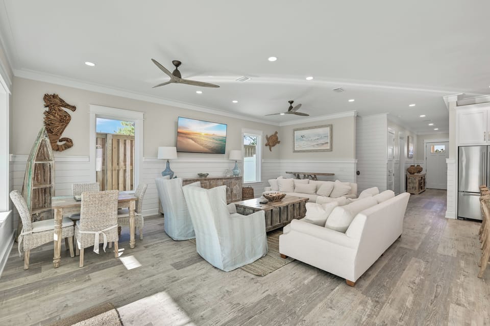Wide angle of the living space, highlighting the airy layout and ceiling fans.