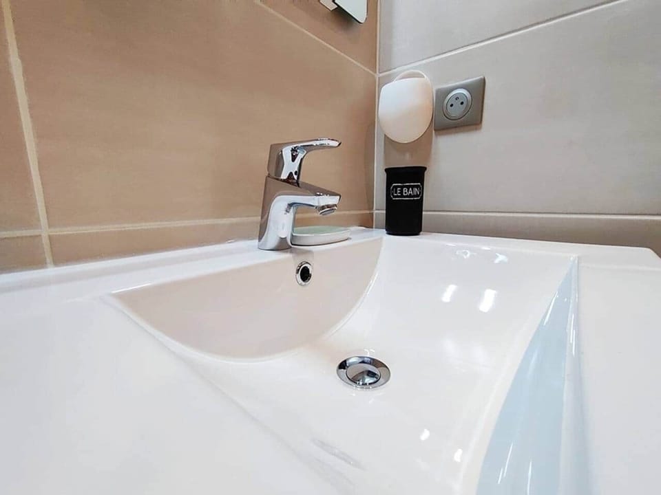 Bathroom with sink, large shower, toilet and storage space