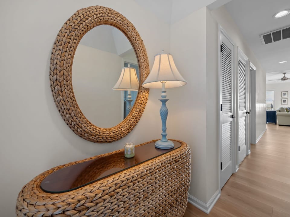 Step into your stylish entryway featuring coastal-inspired wicker furnishings and warm ambient lighting that welcomes you home.