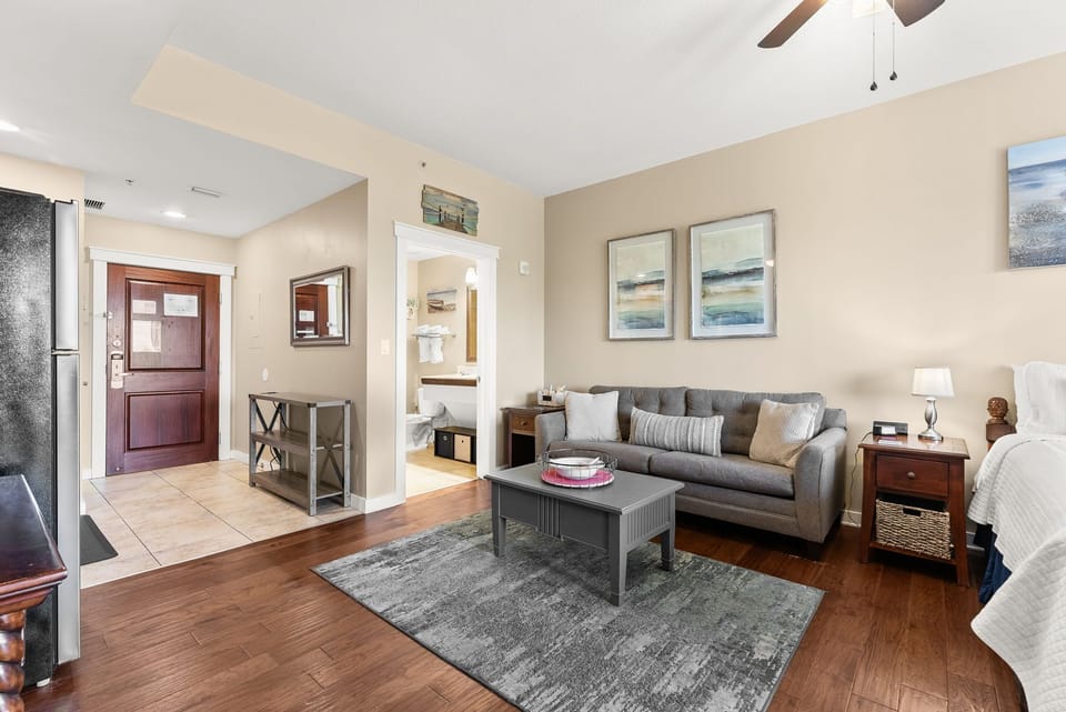 Unwind in your thoughtfully designed suite with comfortable seating, artwork, and warm wood floors creating a perfect retreat.