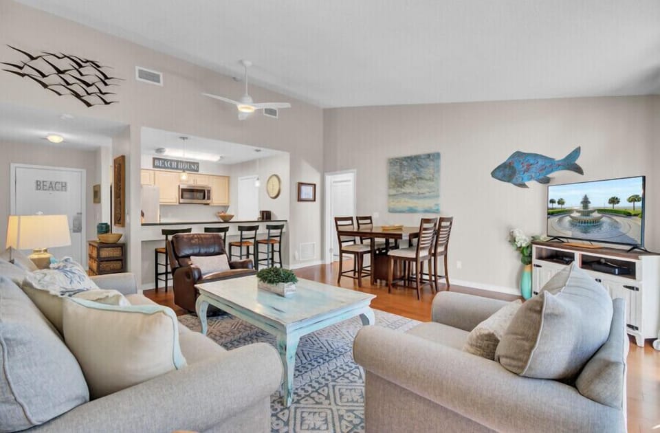 Sink into plush coastal sofas and enjoy your favorite shows while savoring the ocean breeze through this beautifully designed living space.