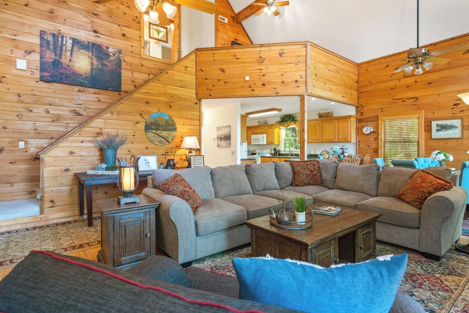Comfortable seating, wood-beamed ceilings, and a stone fireplace create a warm mountain atmosphere.