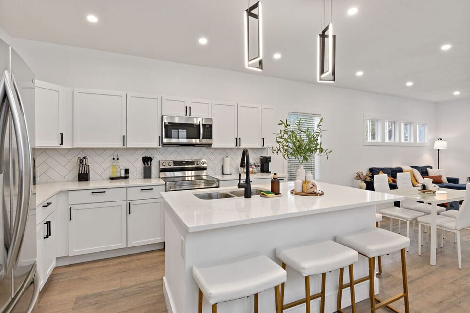 Open-plan kitchen and living - quartz island, stainless appliances, and a seamless flow that makes entertaining effortless.