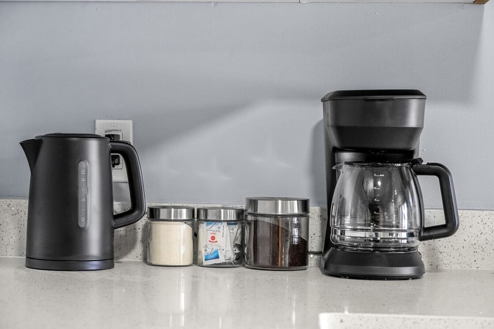 Convenient coffee station with drip maker, kettle, sugar, and ground coffee