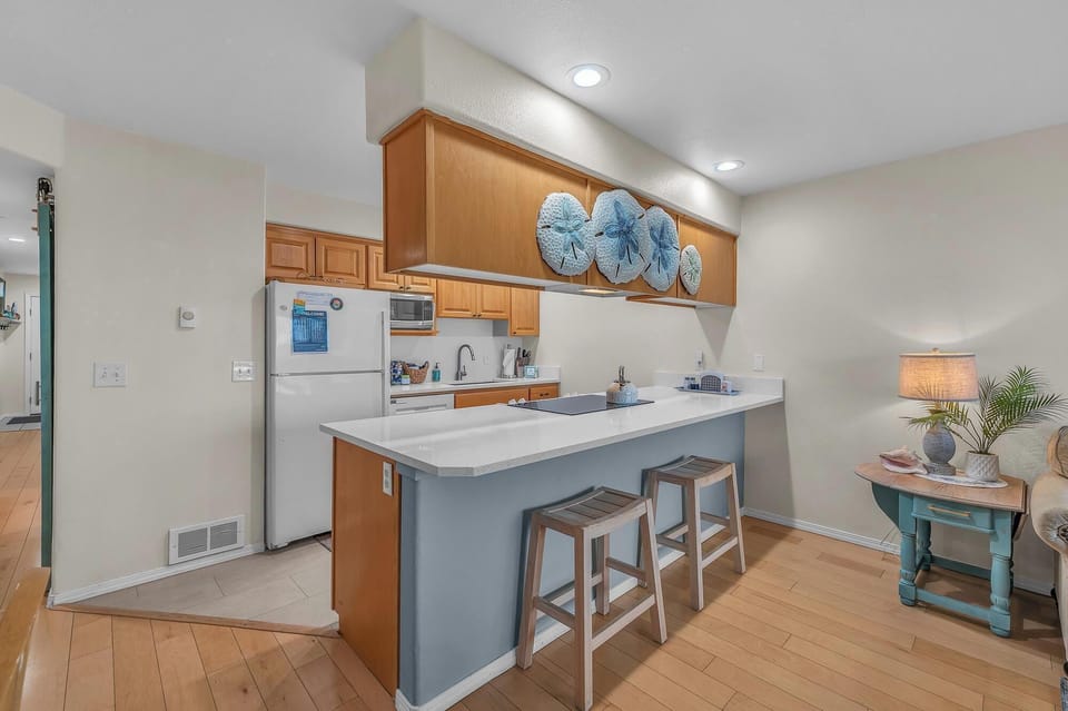 Your fully equipped kitchen features a breakfast bar perfect for morning coffee and quick meals, with modern appliances ready for your culinary adventures.