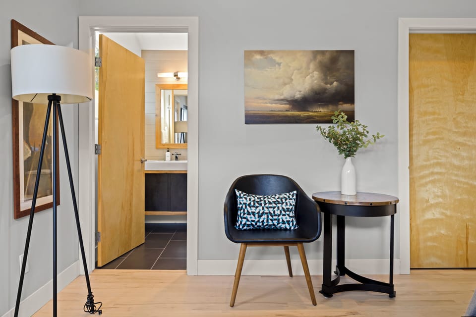 Settle into your stylish reading nook with modern furnishings, warm lighting, and thoughtful artwork creating the perfect retreat.