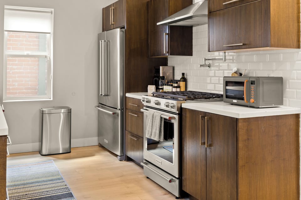 Your fully-equipped modern kitchen features sleek appliances and warm wood cabinets, perfect for preparing memorable meals during your stay.