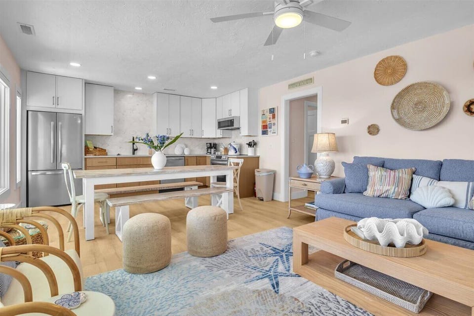 Your open-concept living space combines coastal charm with modern comfort. Relax on the blue sofa or gather around the island for memorable meals together.